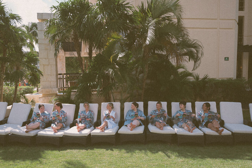 Bridesmaids sat on lounge chairs at a resort in Mexico