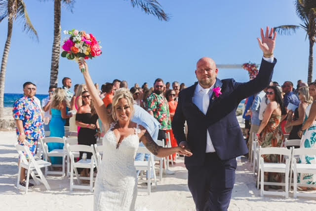 Bride and groom with hands in the air after wedding at Hard Rock Hotel, Riviera Maya.