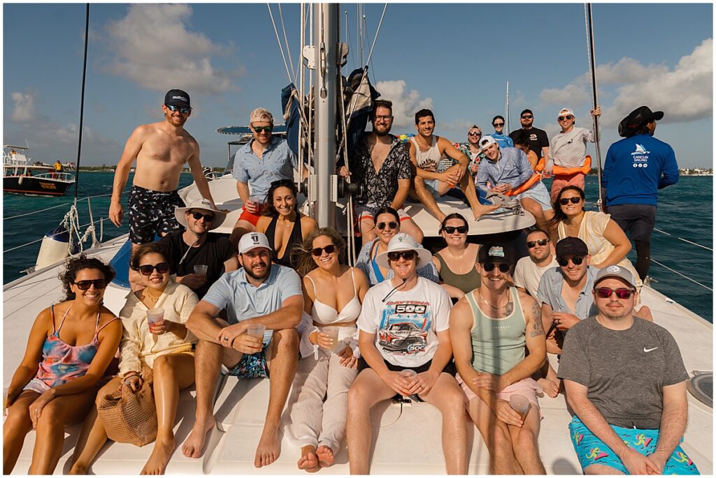 Wedding group sitting on a catamaran in Mexico as part of destination wedding activity