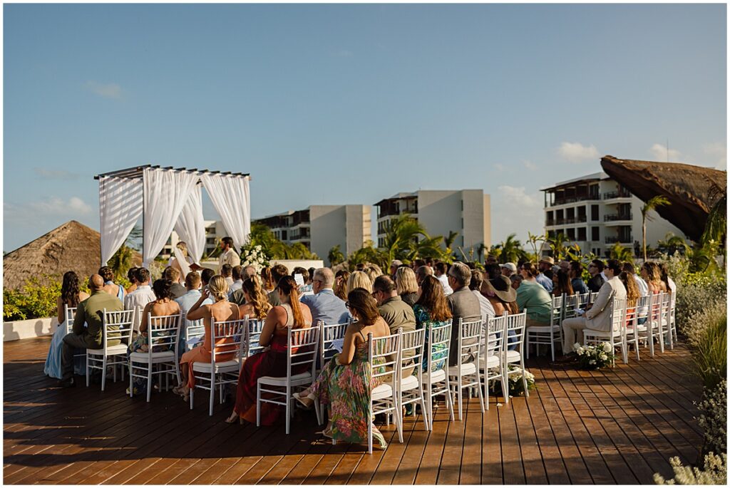 Wedding ceremony taking place outside on the deck at Secrets Playa Blanca