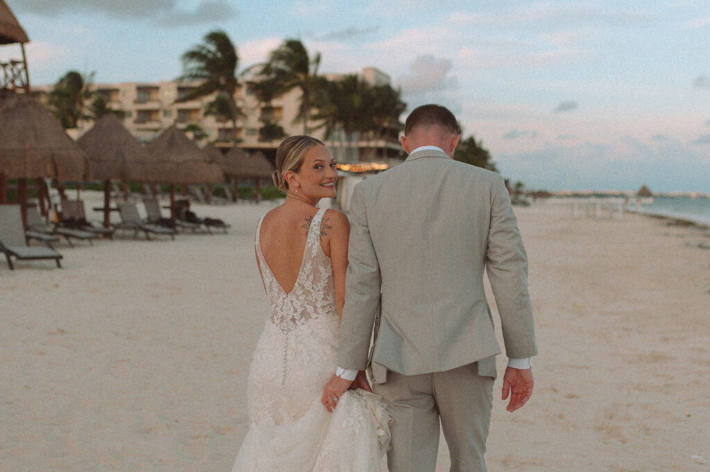 Bride and groom walking along the beach at Mexico wedding